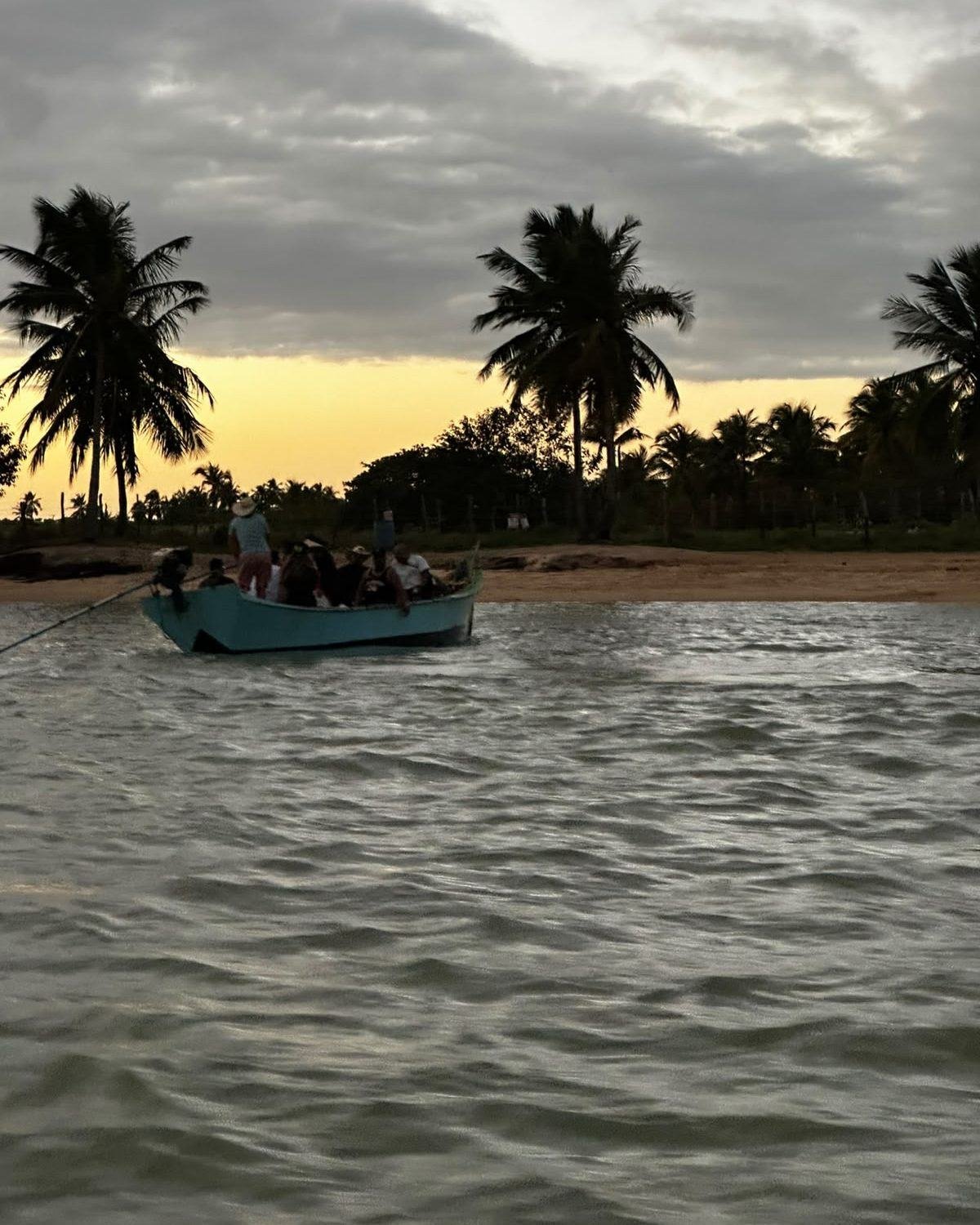 Barco chegando à Boca da Barra ao entardecer